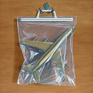 Model airplane inside a clear plastic bag with a clip.