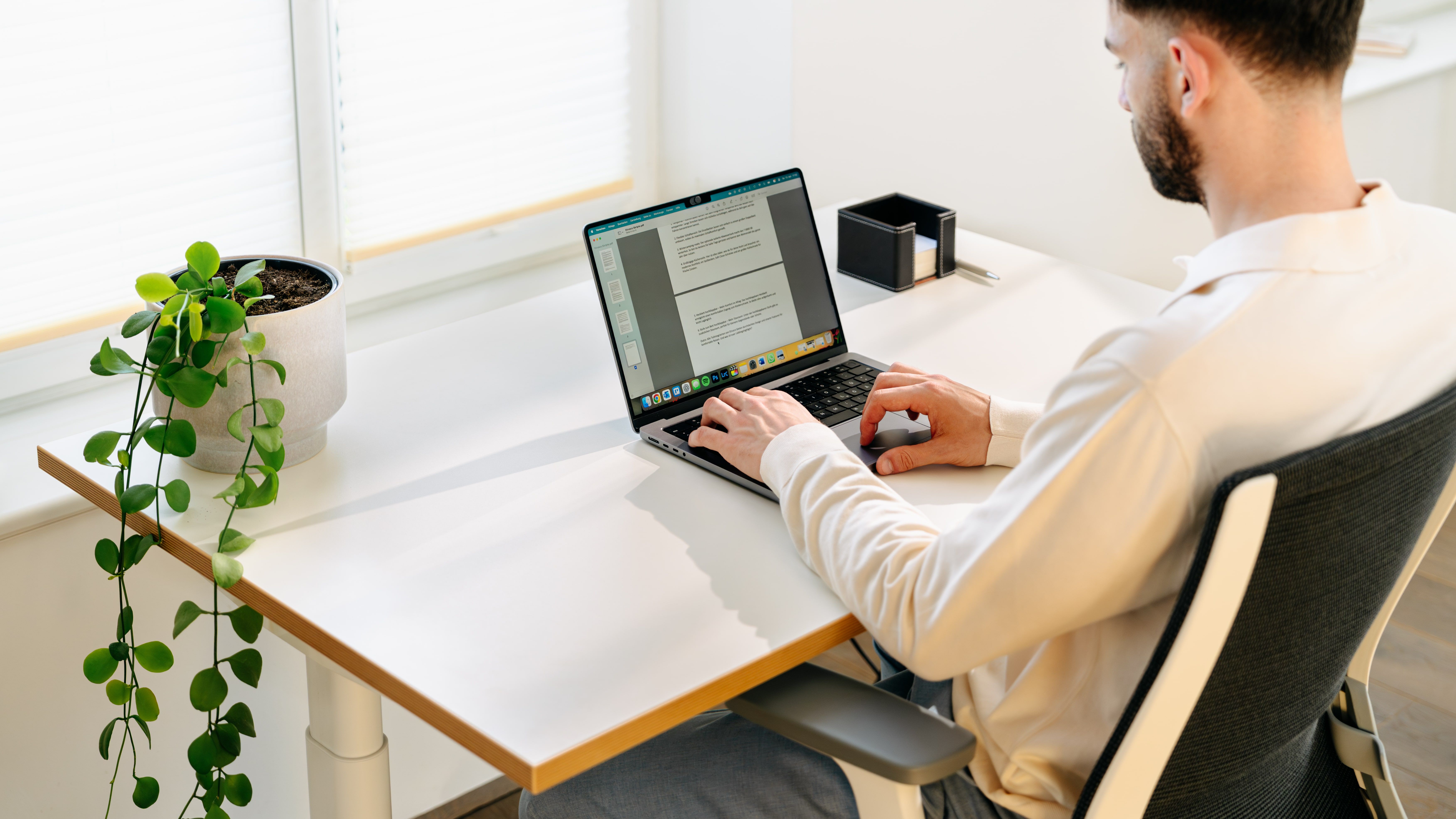 Mann arbeitet an einem Laptop auf einem Bürotisch Rise von ofinto