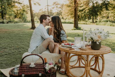 couple kissing during picnic engagement