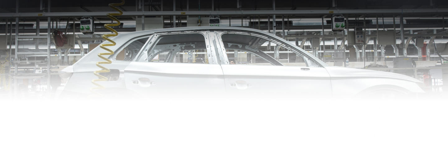 Side view of a car in a manufacturing facility.