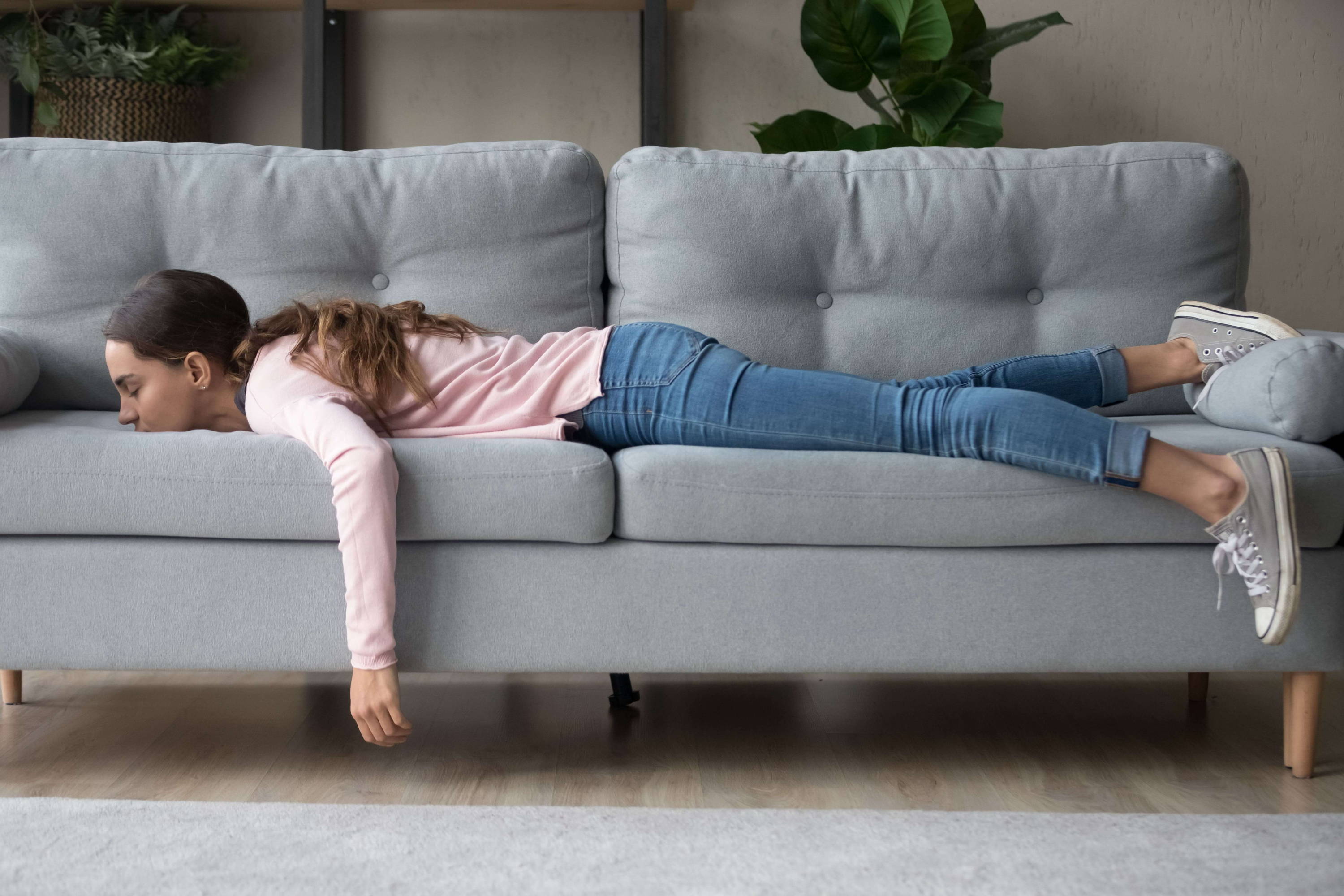 En jente ligger utslått på sofaen – kanskje er hun trøtt og utmattet som en følge av allergi?