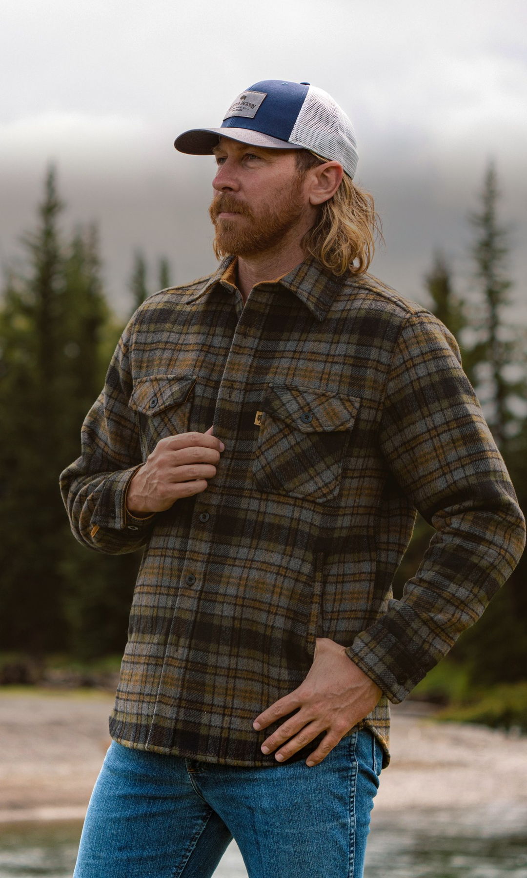 Man wearing a Buffalo Jackson plaid brushed-wool shirt jac in a pine forest
