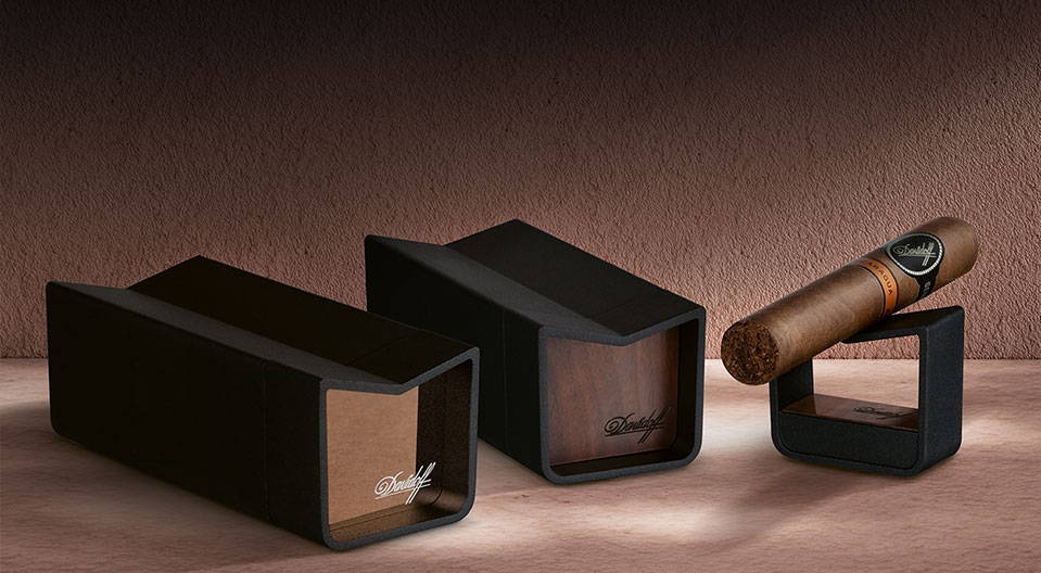 Two Davidoff Sliding Ashtrays, one in each finish, and a cigar stand with a Nicaragua cigar resting on top, all standing next to one another.