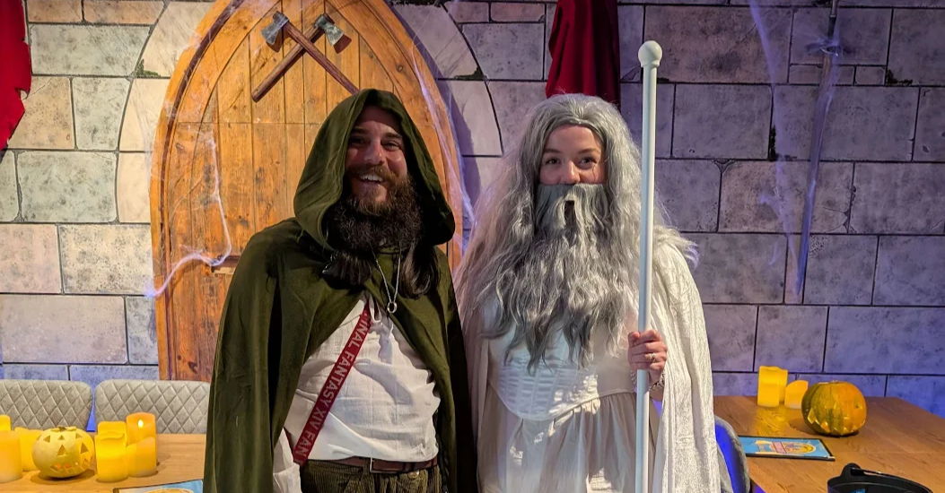 Two characters in costumes standing in a castle-like setting.