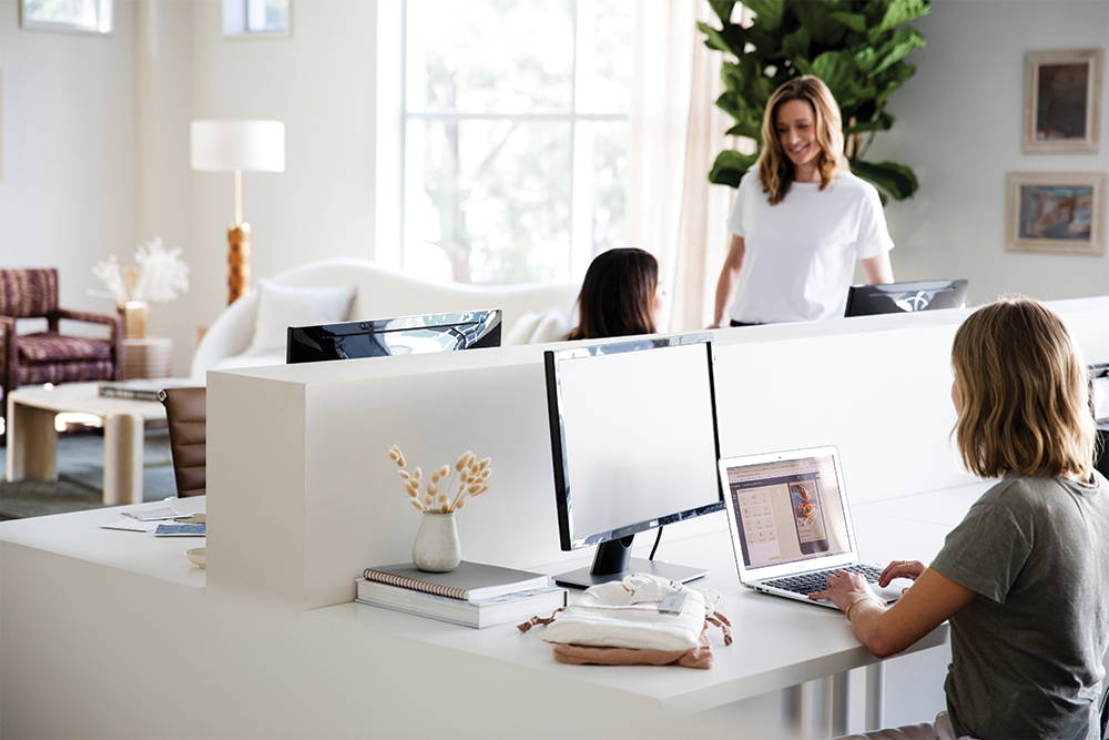 Image shows three Cultiver team members working and conversing at their desks.