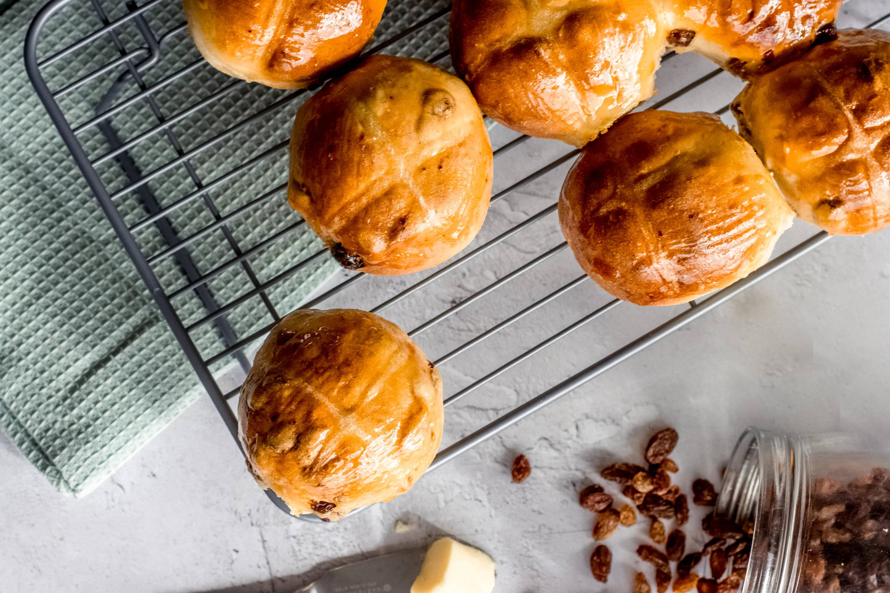 Brioche hot cross buns on a cooling rack.