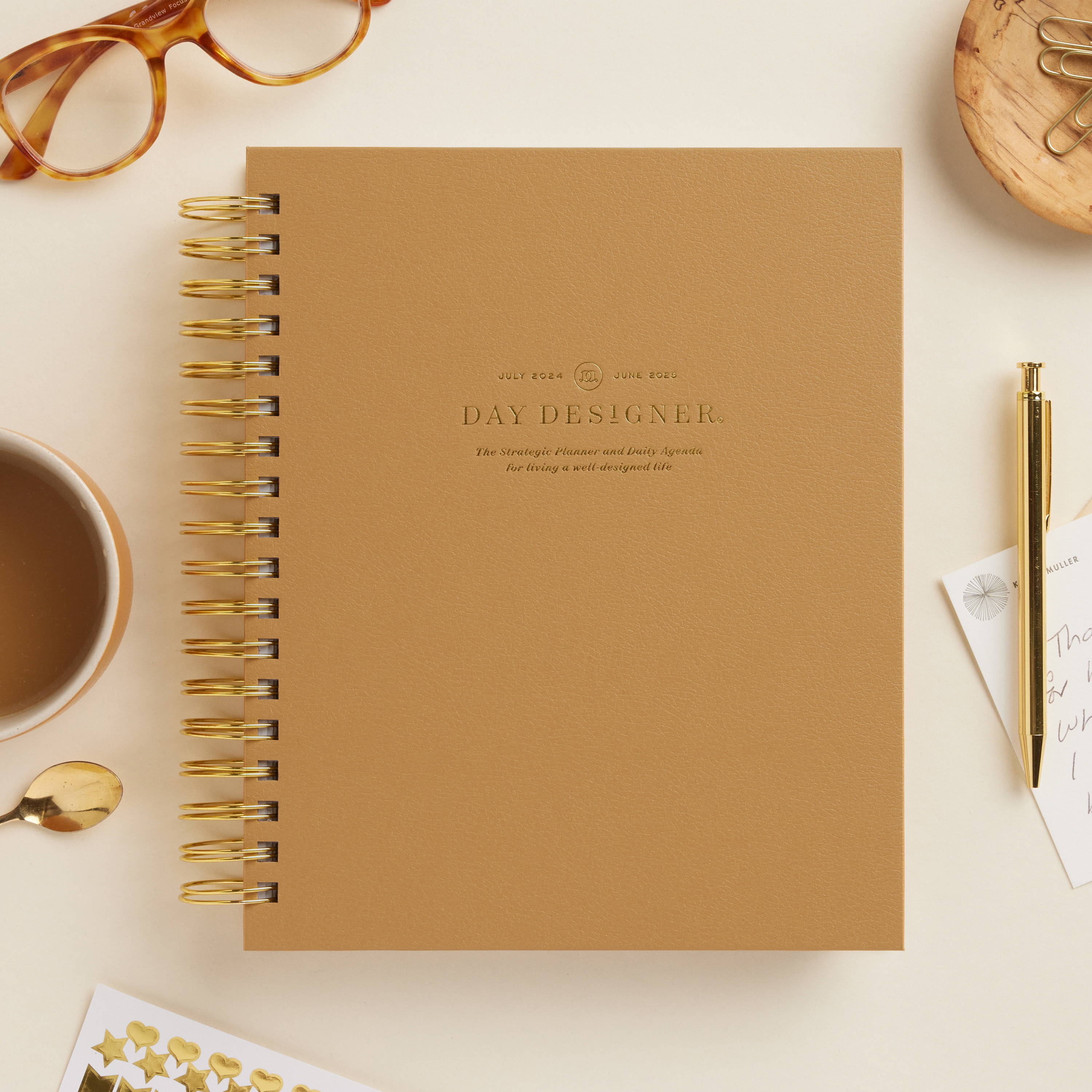 caramel colored closed book planner on beige background