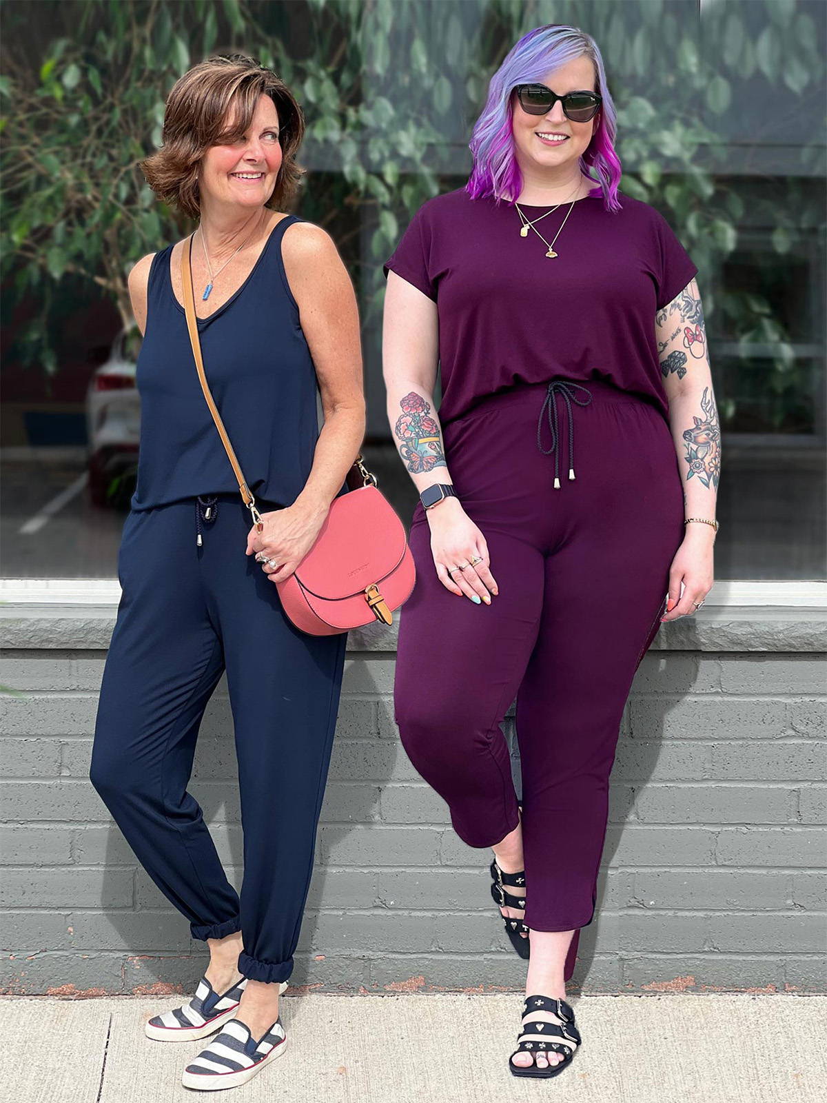 Two women standing in front of a window smiling wearing Miik's Perle open-back sleeveless jumpsuit in navy and Andie open-back casual jumpsuit in burgundy.