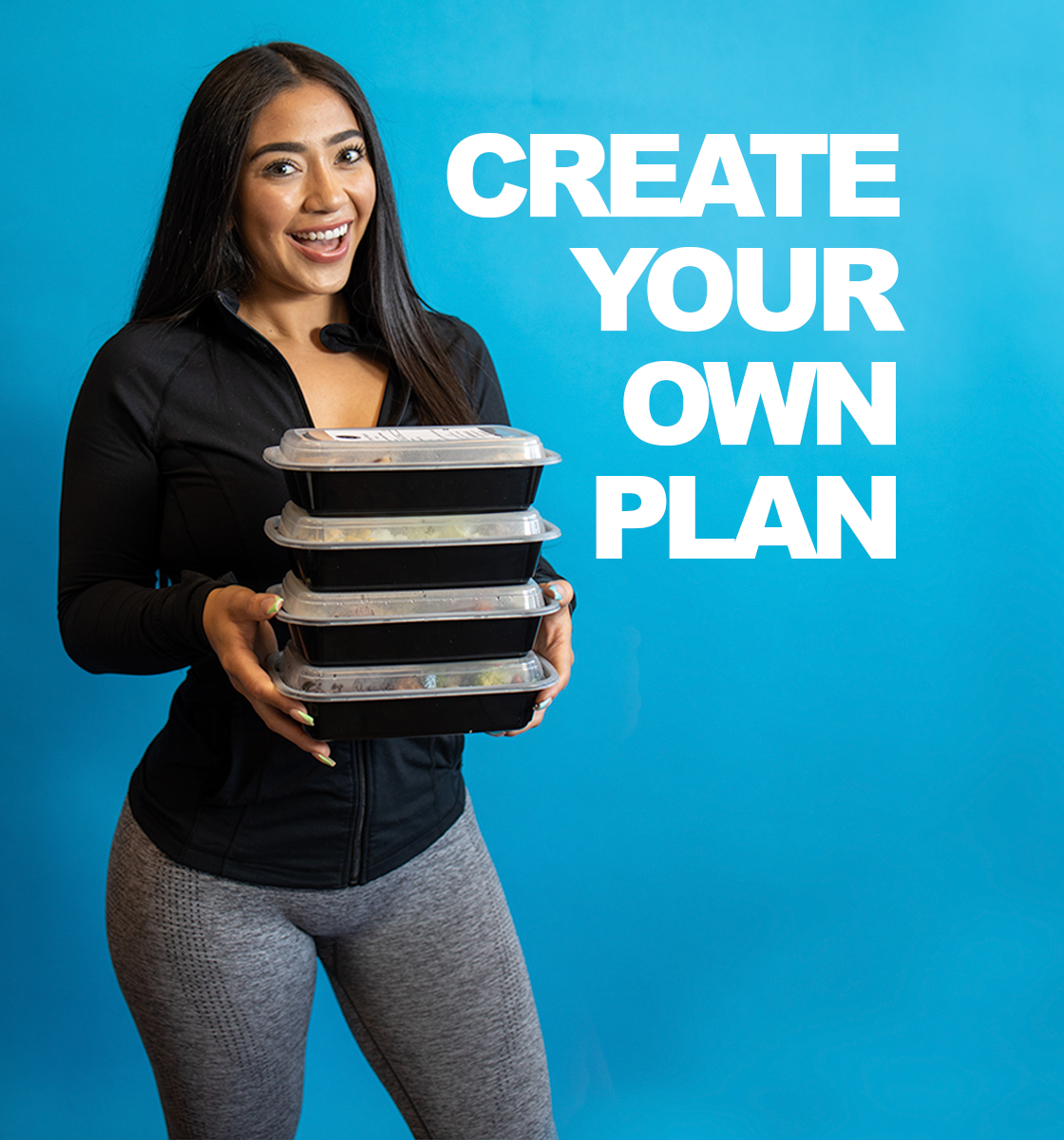 A fit female model holding four spartan meal preps containers that are ready to be sent to anyone looking for healthy delicious meals smiling over a blue backdrop