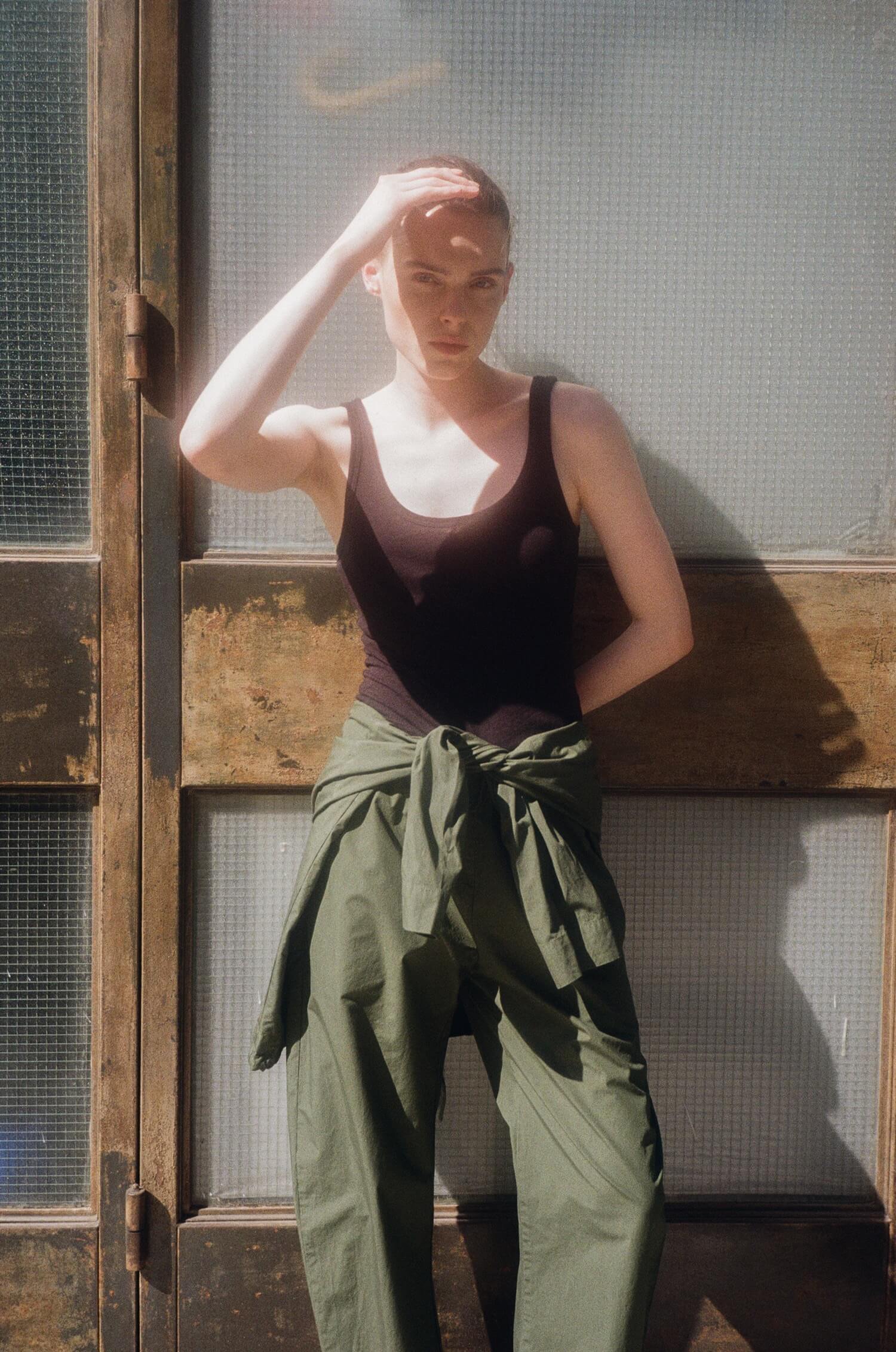 Woman outside in the sun with hand on face to shield from light