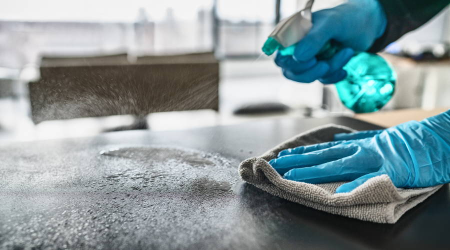 cleaning a surface with a microfiber towel and spray