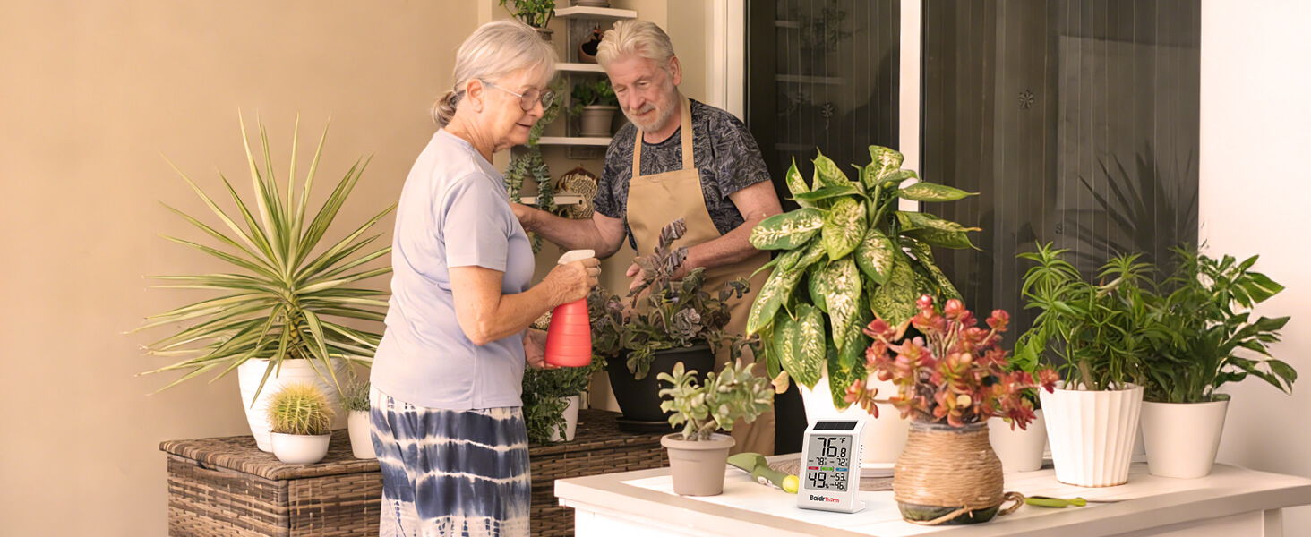 Two women gardening with potted plants on a table.