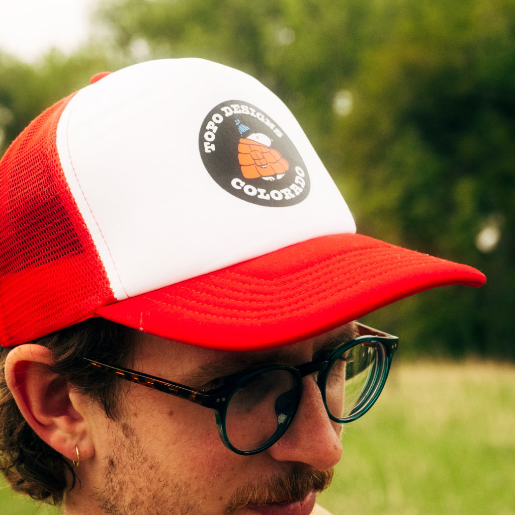 Person wearing a red and white cap in a grassy field.