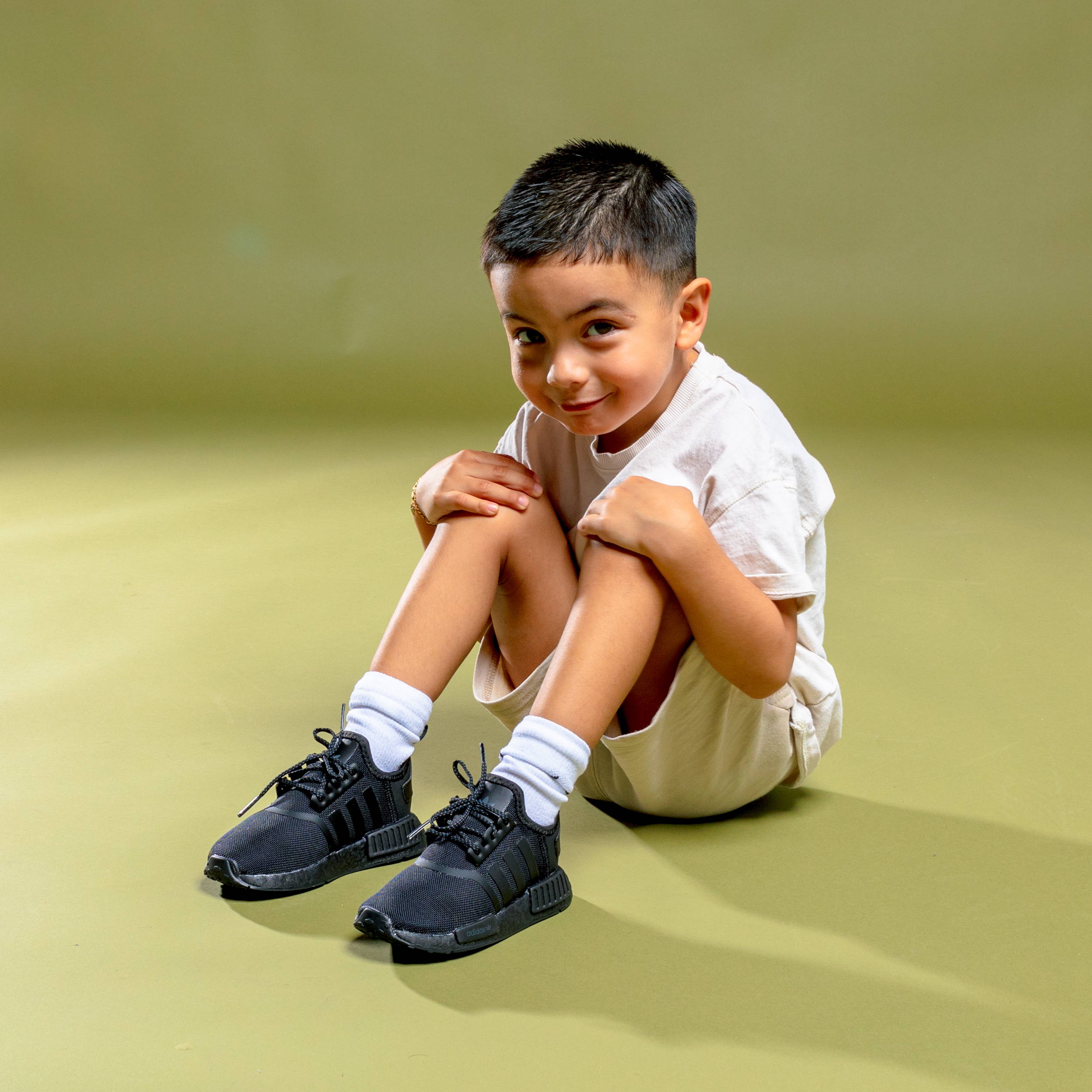 young boy wearing black adidas shoes