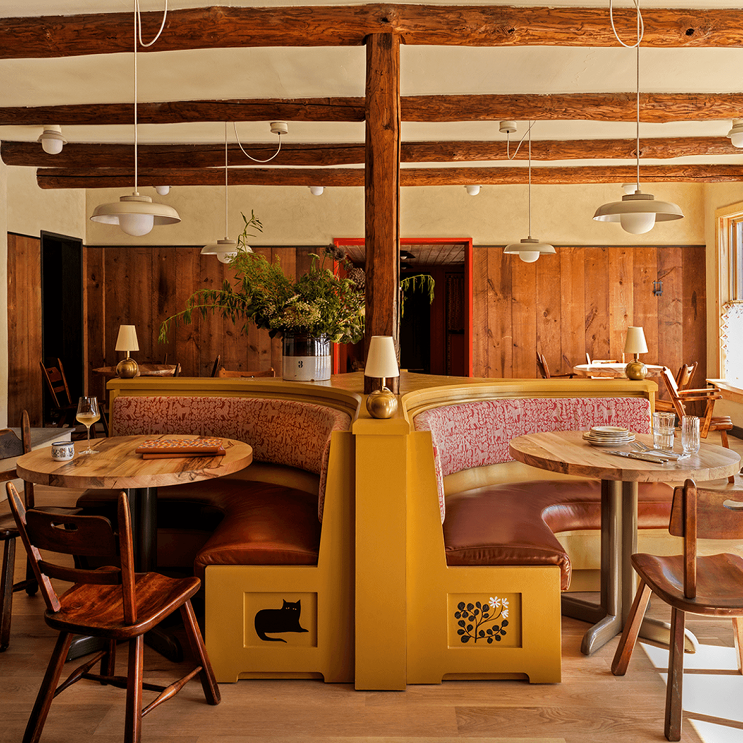 Cozy restaurant interior with wooden beams and stylish seating areas.