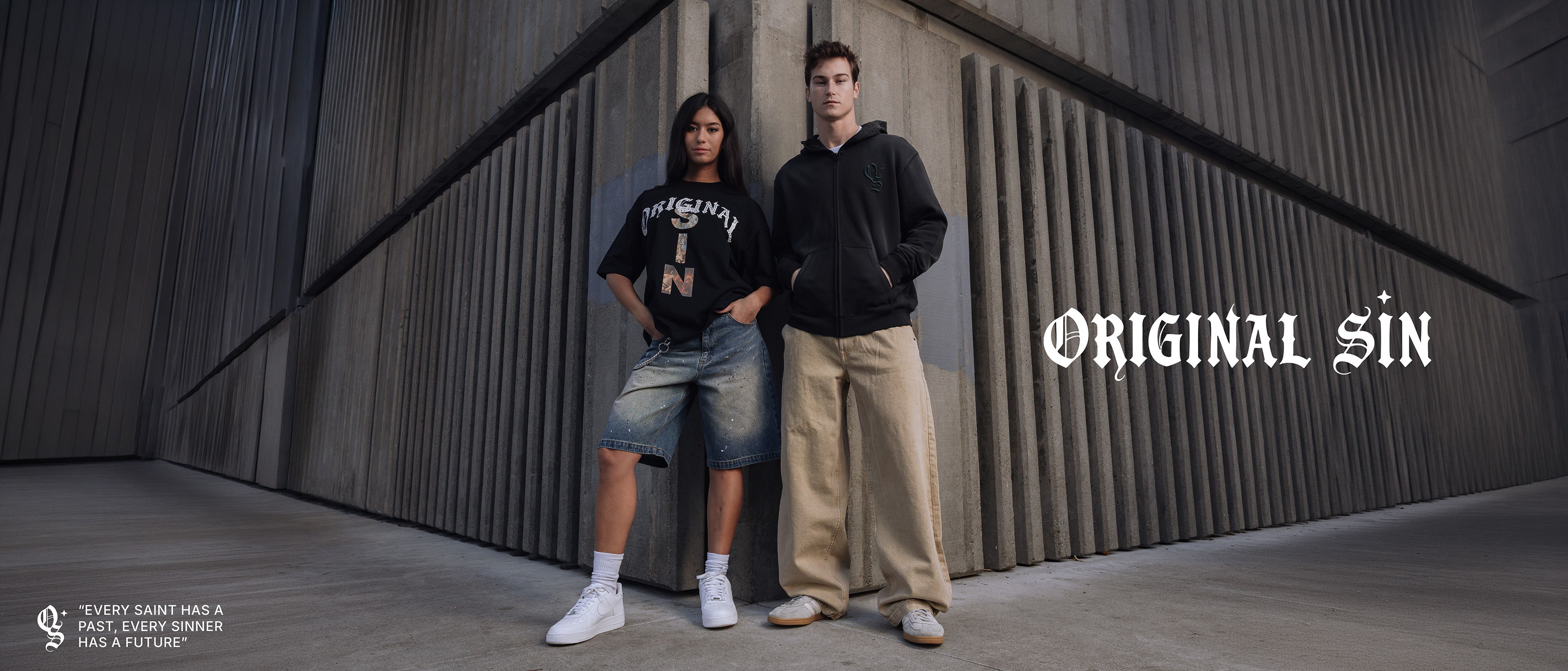 Two people standing against a textured wall with 