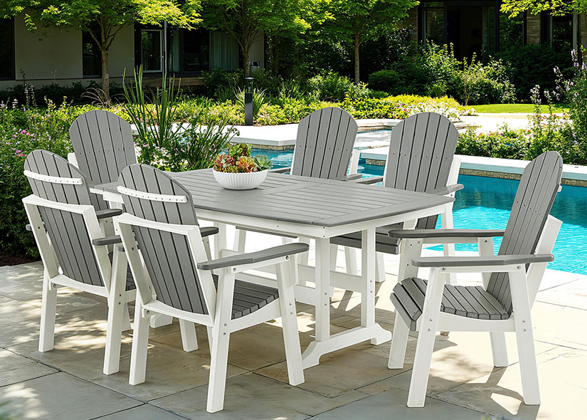 Outdoor dining set by a poolside with chairs and a table.