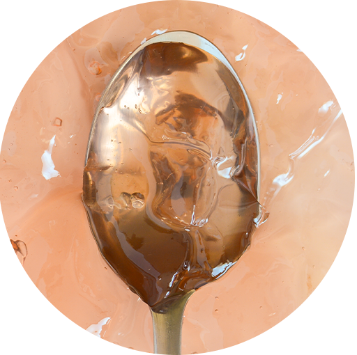 Spoonful of Tastefully Simple Champagne Jelly showing its smooth, translucent golden texture.