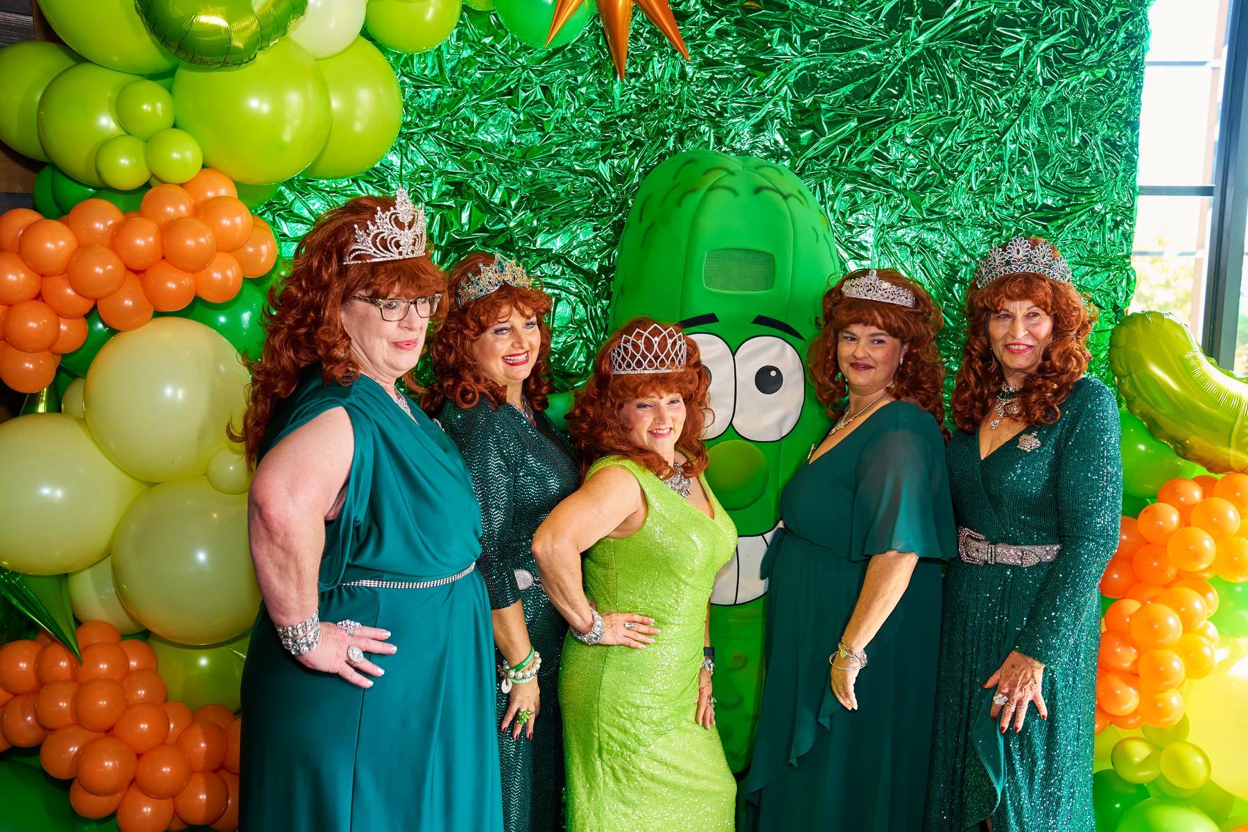The Mansfield Pickle Queens in matching red wigs and green sequined gowns posing with the Big Dill mascot at The Big Dill Arlington Texas 2025.