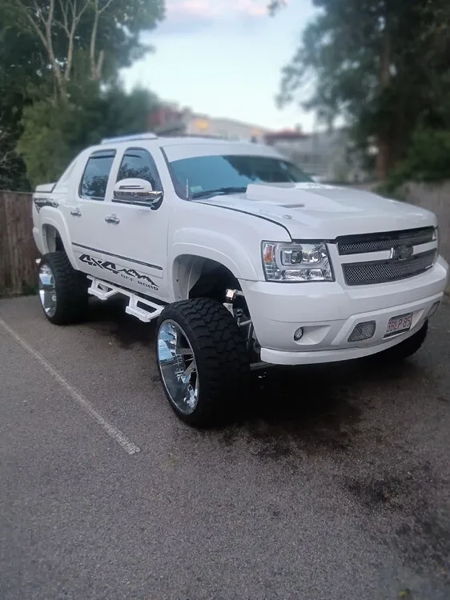 Front three-quarter lifted white 2013 Chevy Avalanche chrome wheels off-road tires Psychoblasters V2 horn kit Melvin's HornBlasters featured customer install gallery photo 1