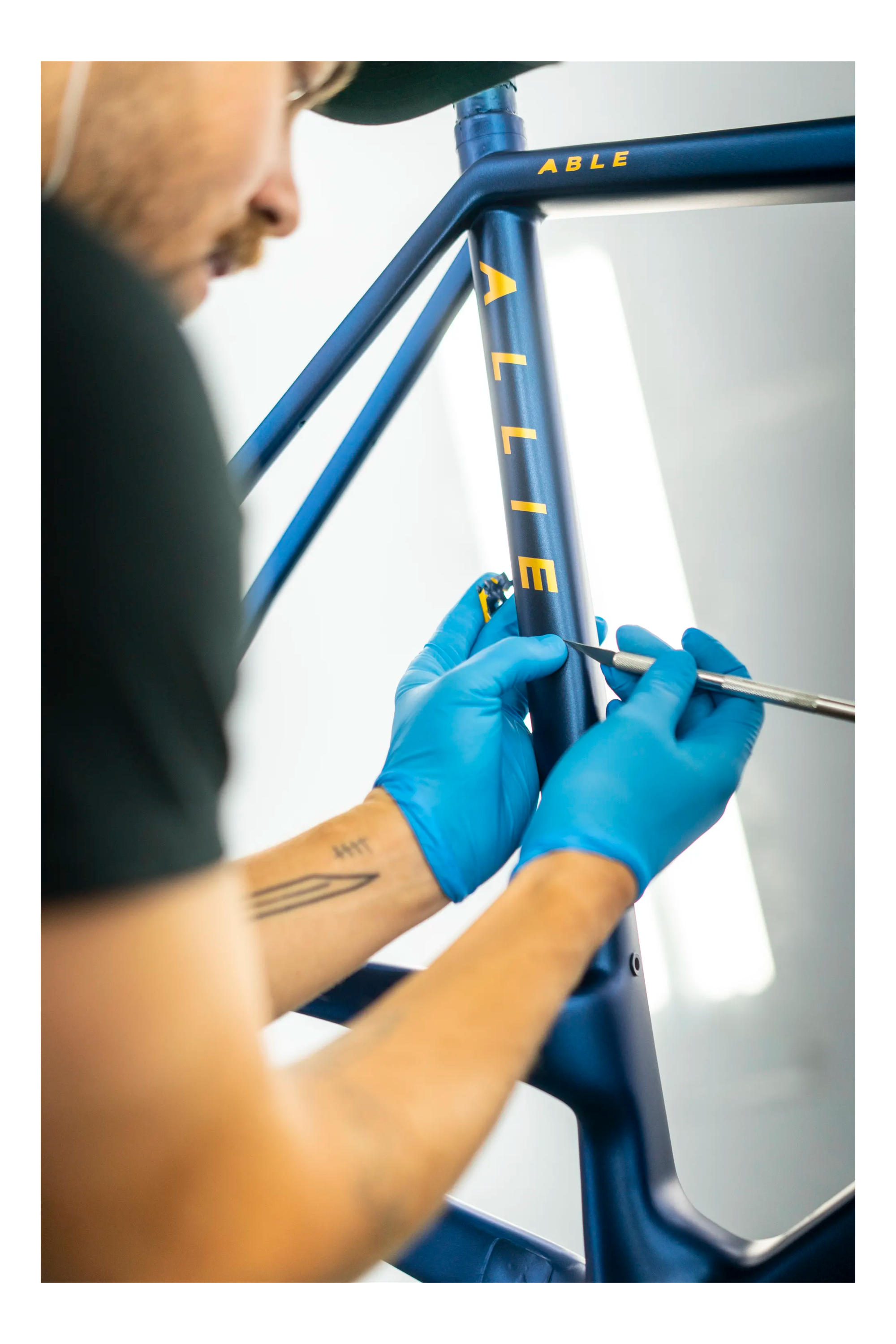 A bike tech adding the ALLIED graphic to a bike frame