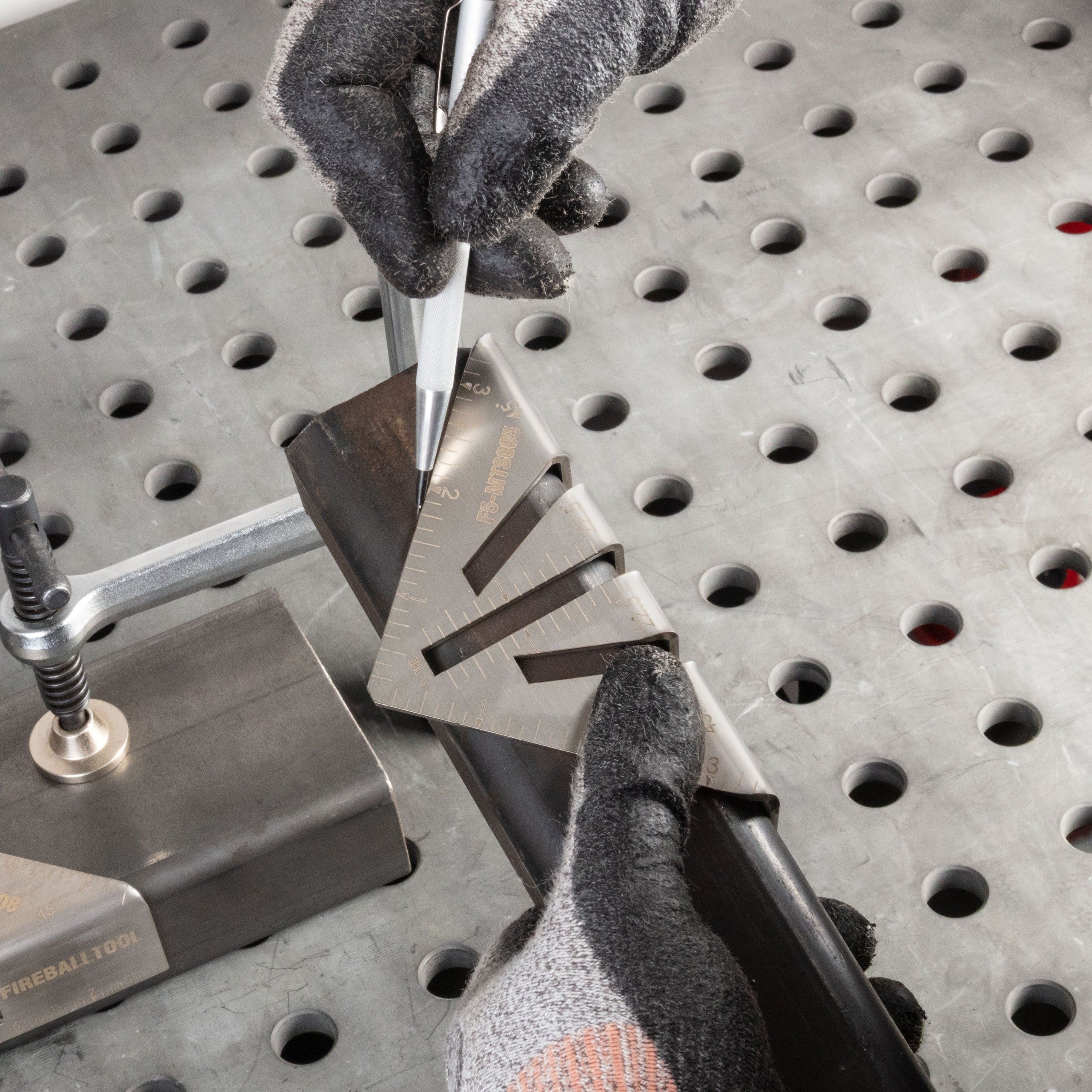 Person using a caliper to measure metal on a workbench.