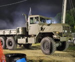 Side profile olive drab M923A2 5 ton 6x6 military cargo truck night spotlights smoke American flag exhaust stack Benjamin's Outlaw train horn featured customer install gallery photo 1