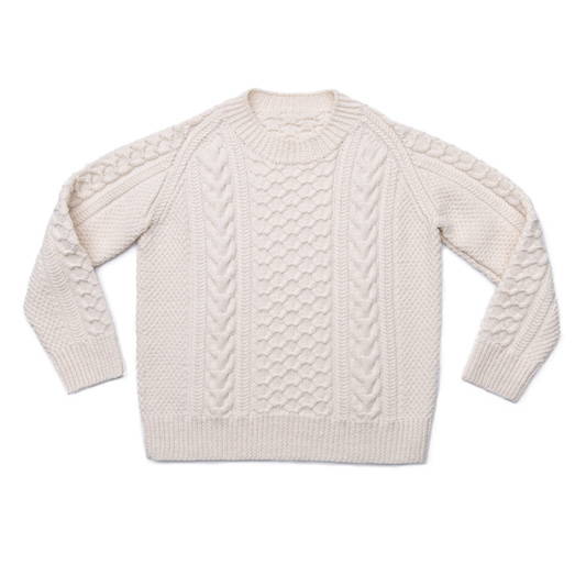 A hand knit fitted cabled pullover photographed flat on a white background 