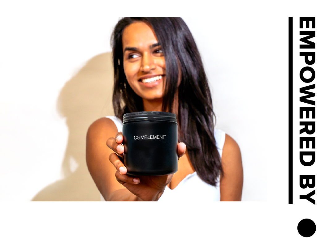 Plant-based woman holding glass jar for Complement Essential vegan multivitamin. 