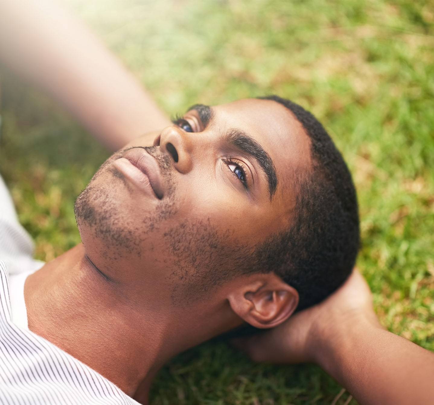 Symptômes d’allergie au pollen de graminées? Cet homme allongé sur l’herbe, les mains derrière la tête, n’en souffre pas ou les a sous contrôle. 