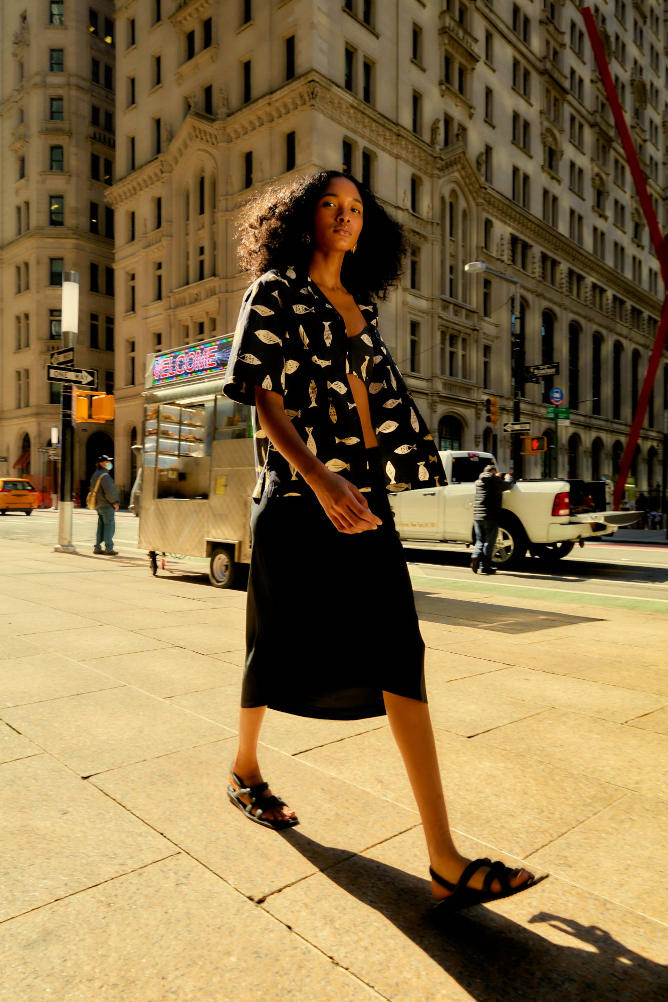 A person walking in a city street wearing a stylish outfit.