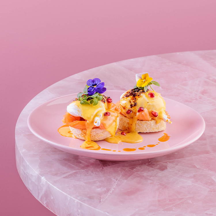 Eggs Royale with salmon with flowers on a pink plate