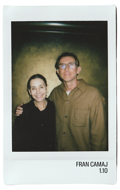 Two people posing for a photo with a dark background.