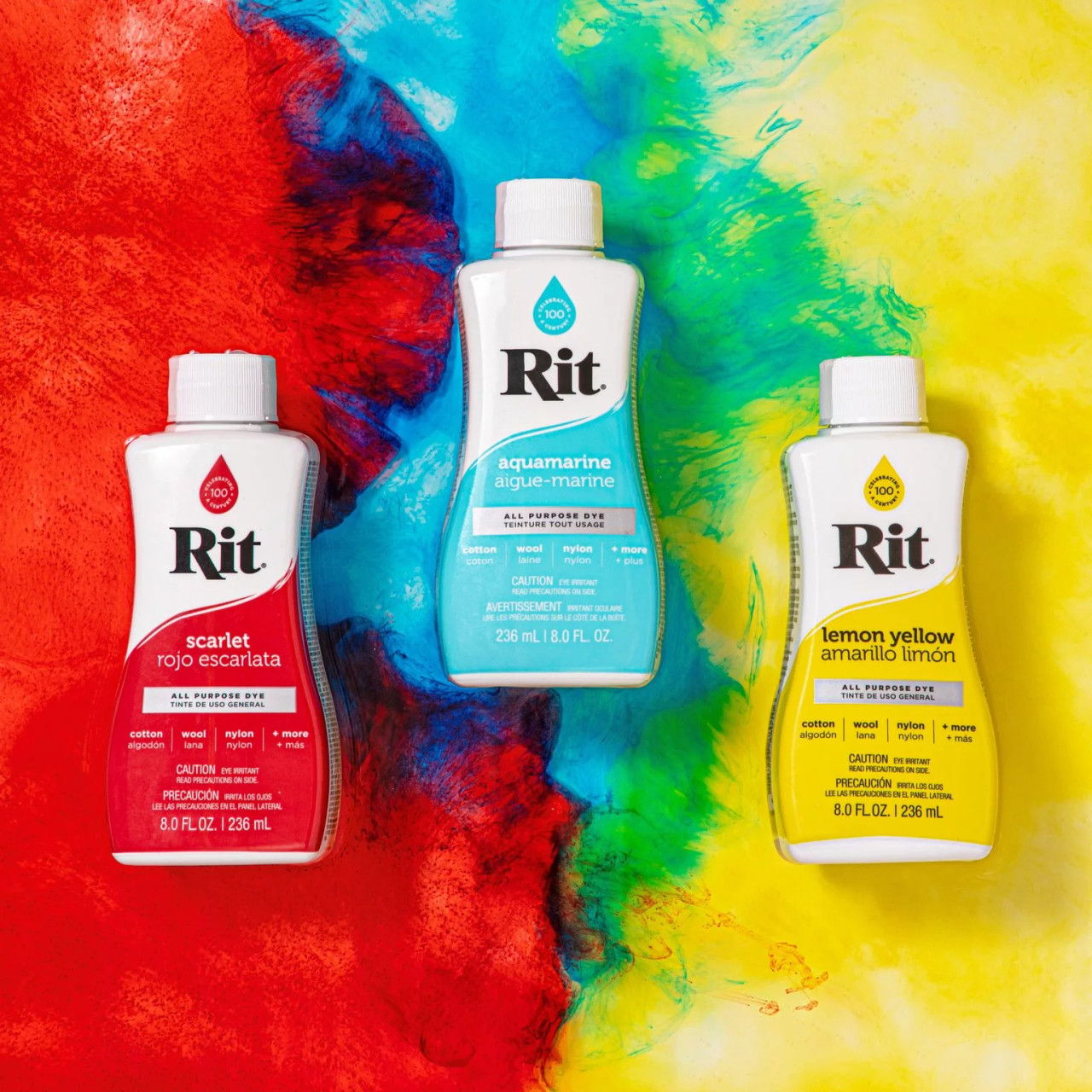 Three bottles of Rit dye on a colorful background.