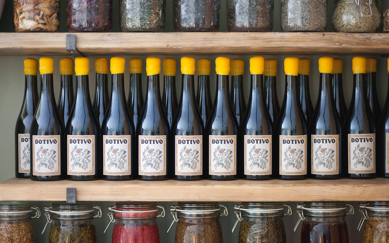 A lifestyle shot of multiple Botivo bottles sitting on a shelf amongst herbs and spices.