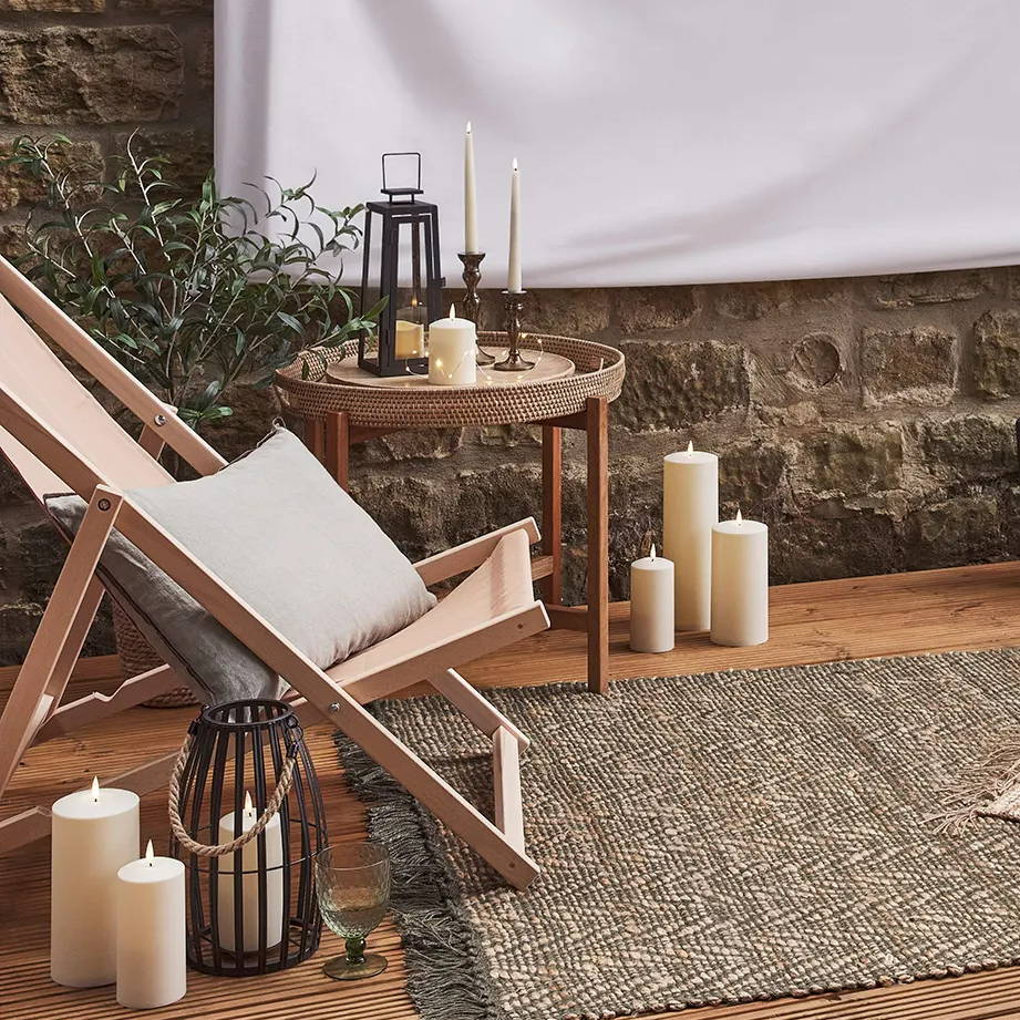 A deck chair and cushions in an outdoor summer setting.