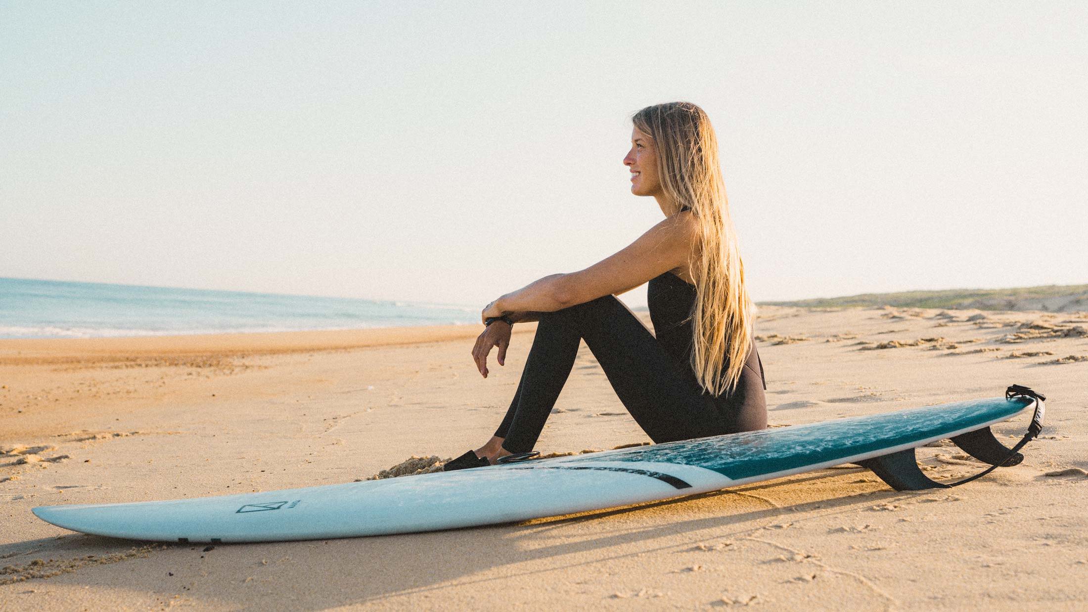 Girl sitting at the beach with our Mini Malibur Surfboard Icebreaker