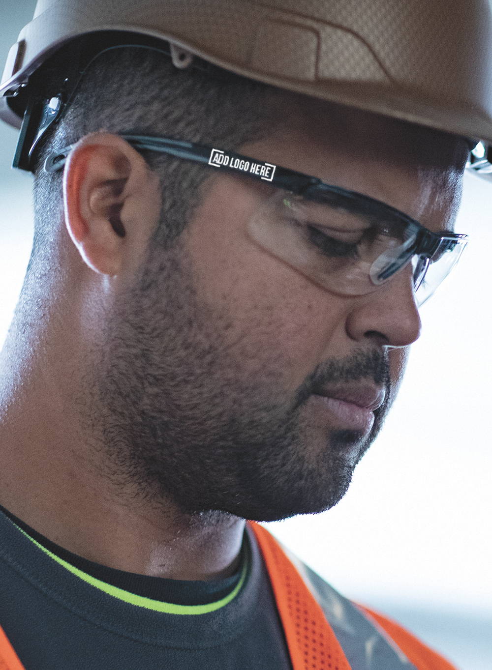 Construction worker wearing hard hat, hi-vis vest and safety glasses with company logo custom printed on the temple of the safety glasses.