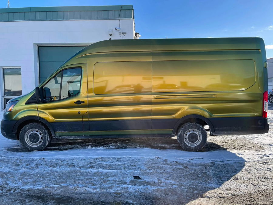 Side profile olive green gold iridescent Ford Transit high-roof cargo van snow cinder block building Taylor's Conductor's Special 228H featured gallery photo 1