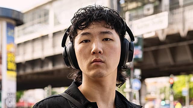 Person wearing headphones in an urban setting.