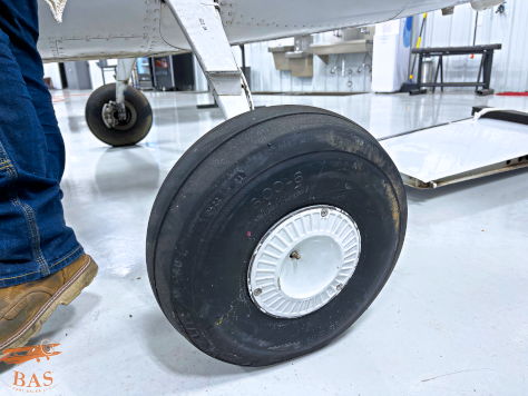 Close-up of an aircraft tire on a hangar floor.
