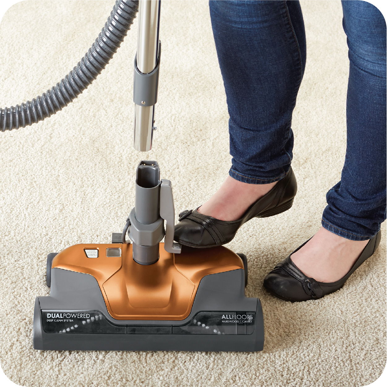 Person using a vacuum cleaner on a carpet.