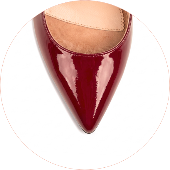 Red patent leather pointed-toe shoe from a top-down view.