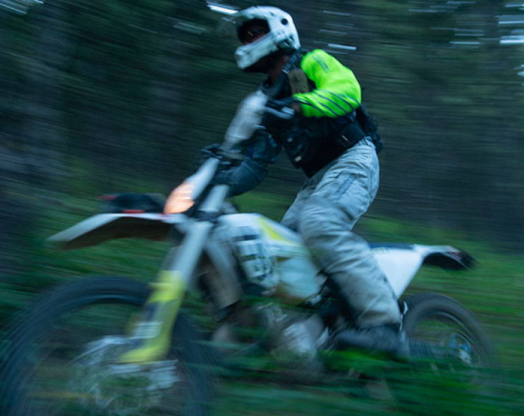 BMX cyclist on trail in the woods.