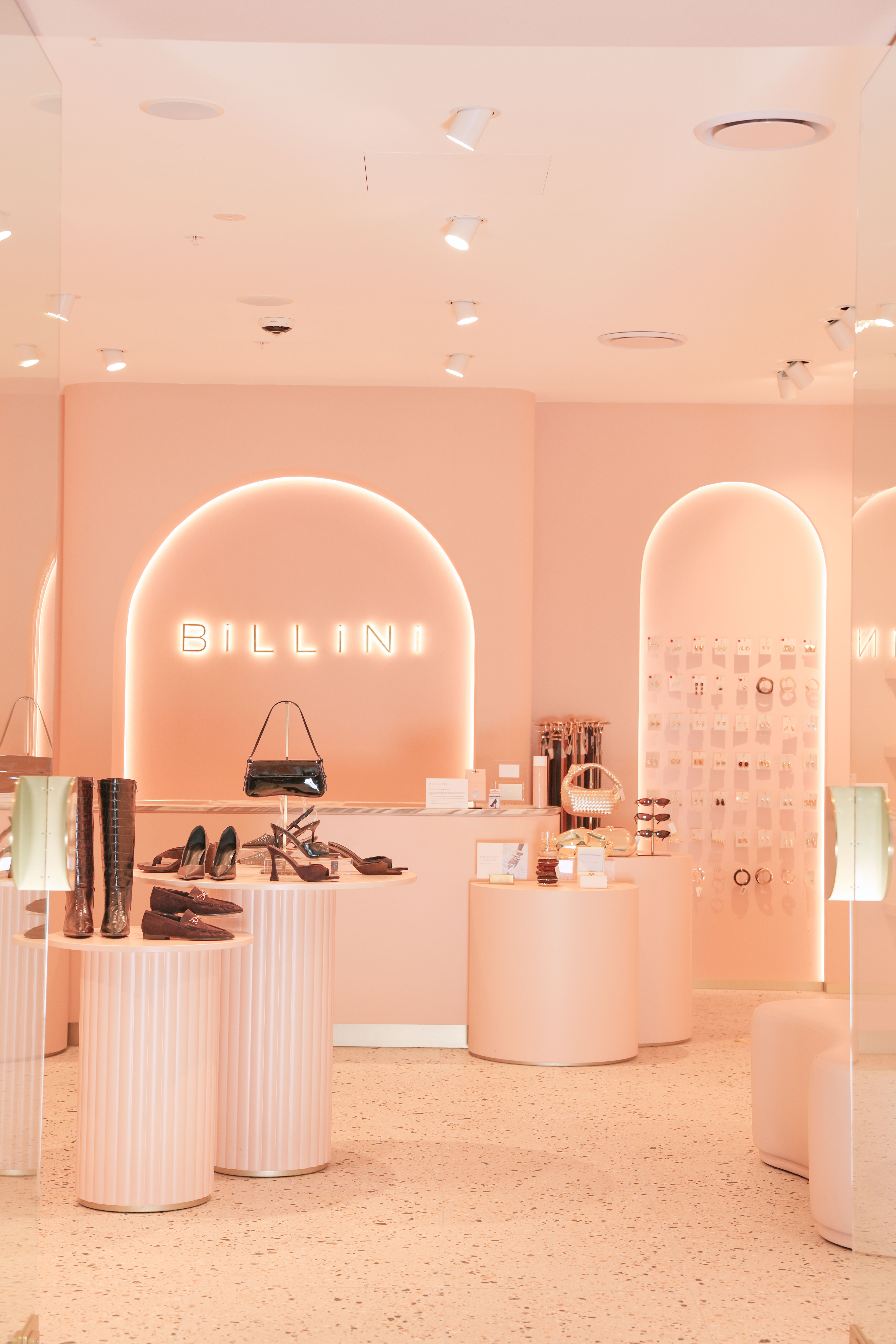 A stylish shoe store with pink decor and modern displays.