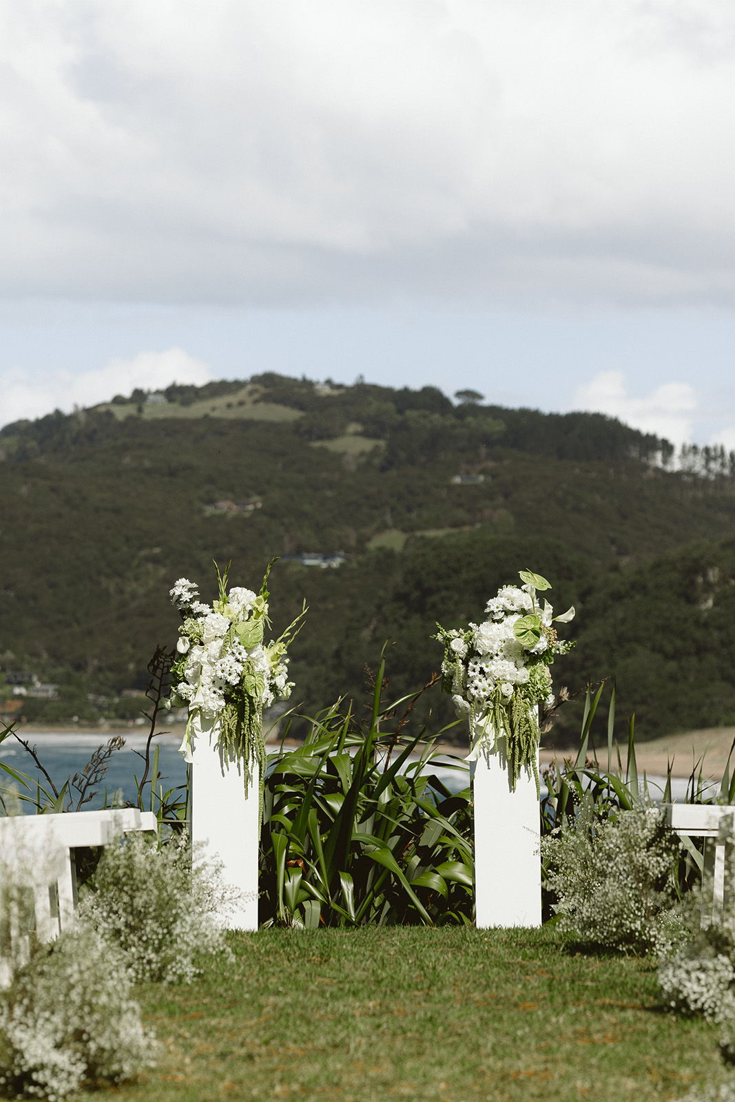 Wedding altar decorated with white flowers, overlooking a scenic landscape.