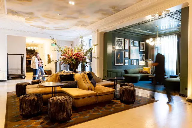 Modern lounge area with seating, artwork, and people interacting.