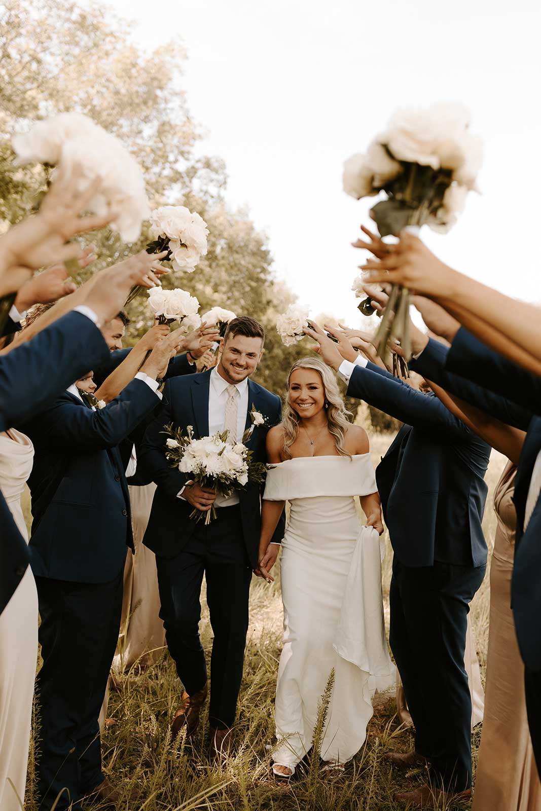 Bride and groom walking through guests