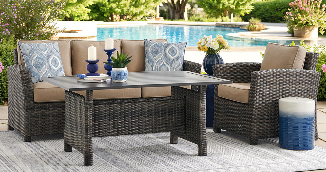 Outdoor seating area with a table, cushions, and decorative items.