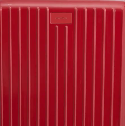 Red suitcase with vertical stripes and a small branded label.
